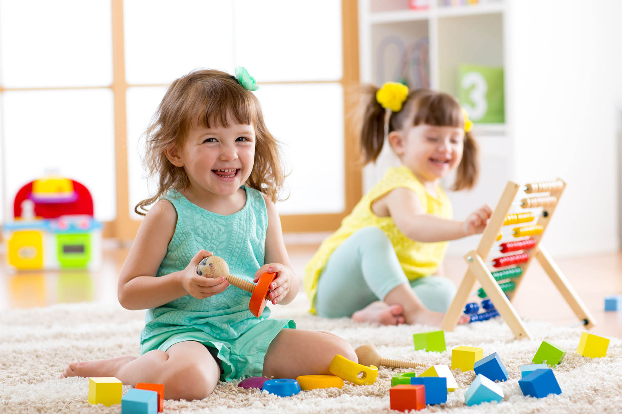 Toddler girls playing with colorful montessori educational toys