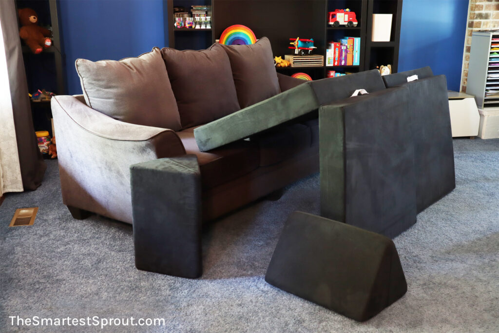 Cave of Mystery nugget fort built with one Nugget play couch using a sofa as one wall for enclosed indoor play