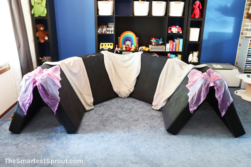 Cave of Mystery nugget fort built with one Nugget play couch using a sofa as one wall for enclosed indoor play