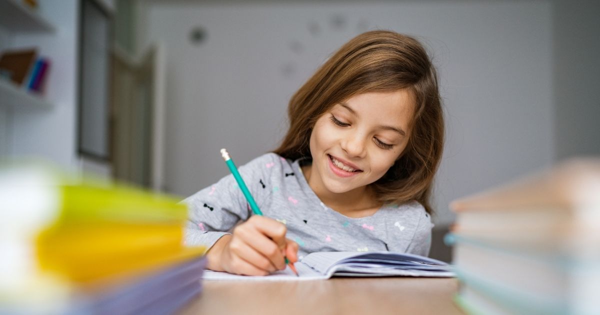 Girl studying workbook while learning systematic theology for kids