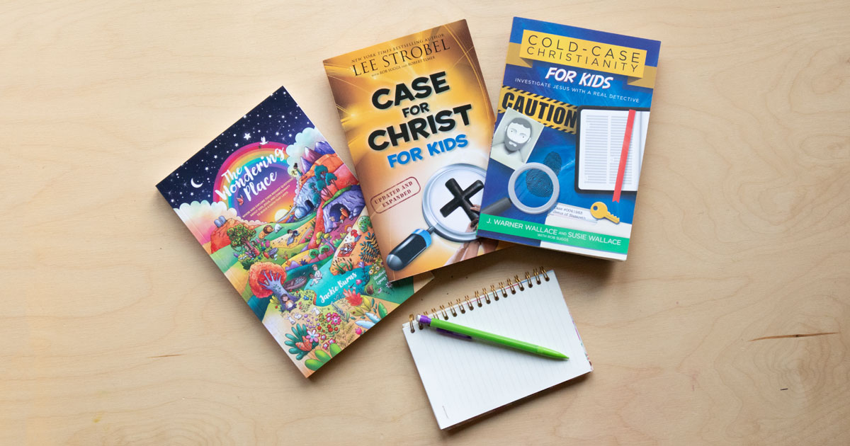Flat lay of Christian apologetics books for kids ages 8–12 on a wooden table, including The Wondering Place, The Case for Christ for Kids, and Cold-Case Christianity for Kids.