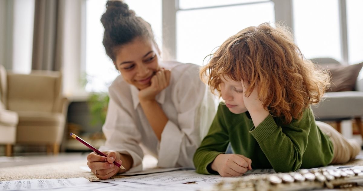 parent helping child learn bible at home through reading and writing activities